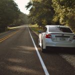 A picture of a small car parked on the side of the road waiting for roadside assistance.