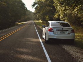 A picture of a small car parked on the side of the road waiting for roadside assistance.